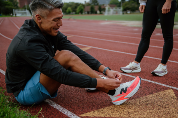 Man tying New Balance shoes