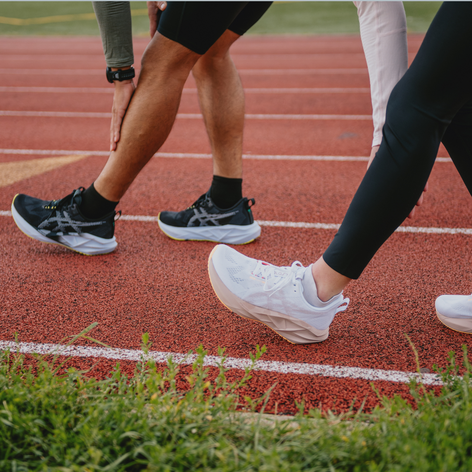 Runners wearing ASICS shoes on a track
