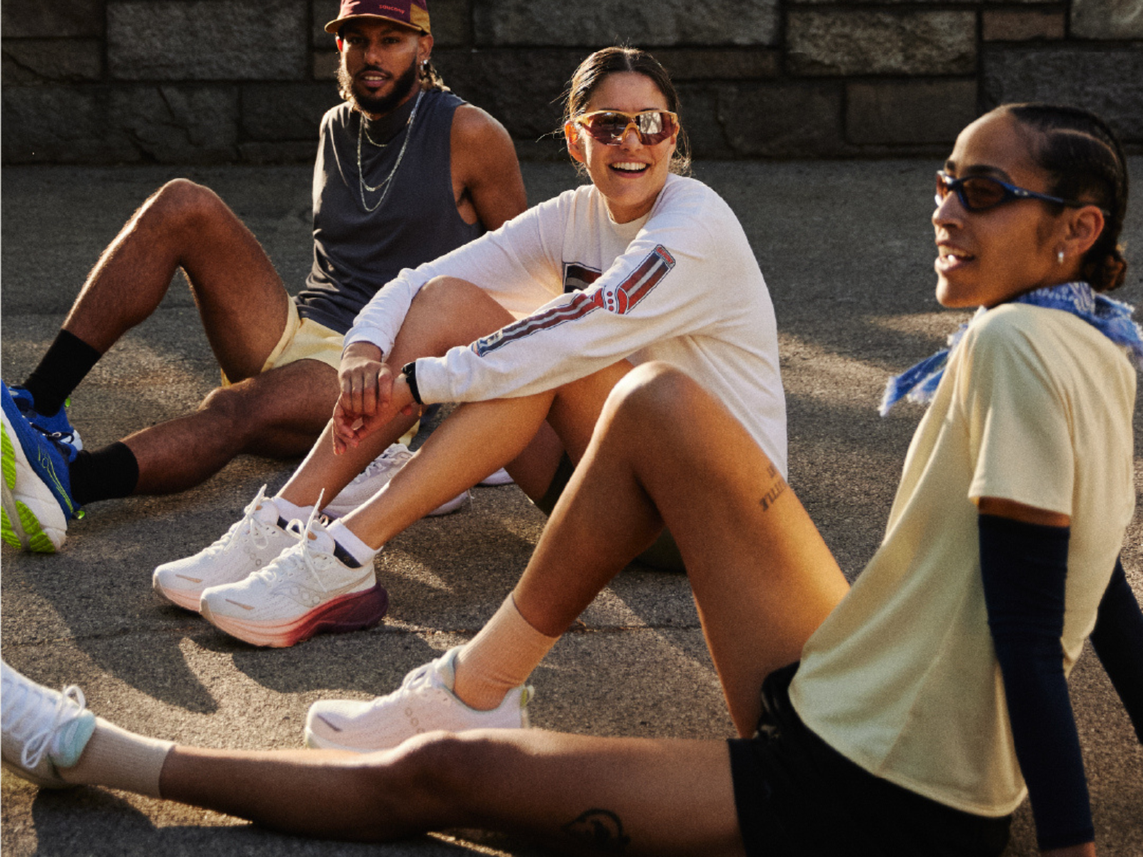 A group of runners sitting on the ground wearing Saucony gear