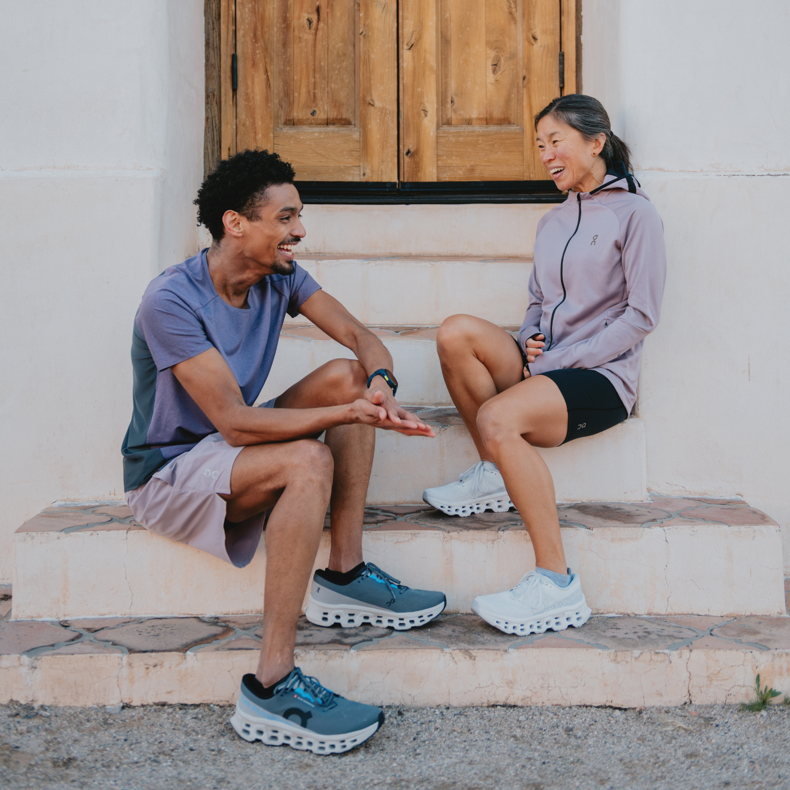 Two runners sitting on steps wearing On Cloudmonster 3 shoes