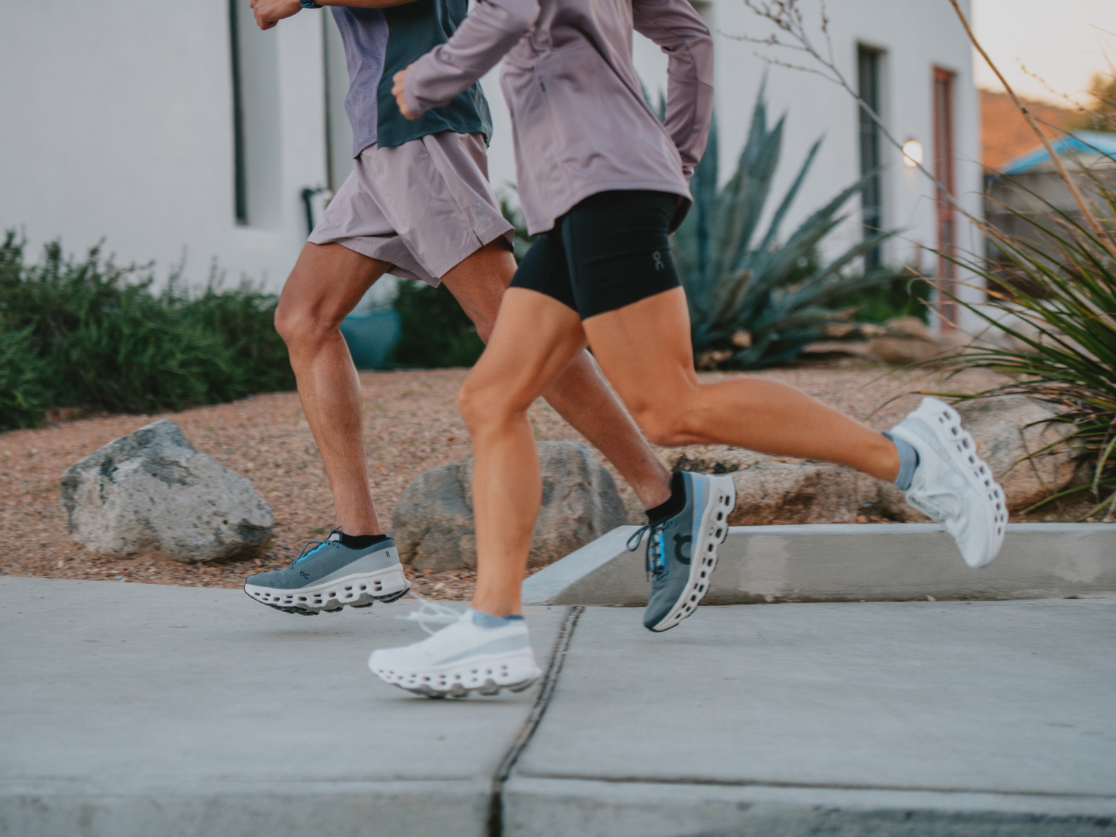 Two people running wearing On Cloudmonster 3 shoes