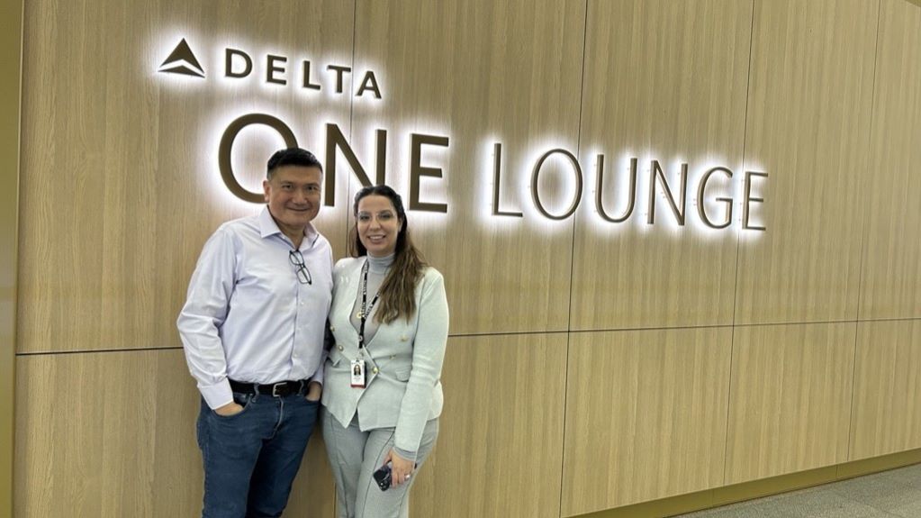 Todd O., Delta's 15 million miler, poses outside of a Delta One Lounge with a Delta employee.