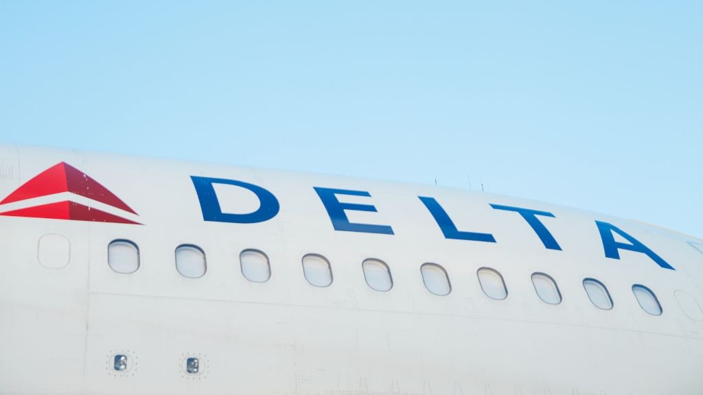 The side of a Delta plane against a blue sky