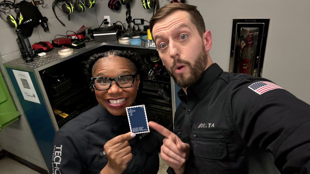 Two Delta employees hold up a Holiday Medallion card
