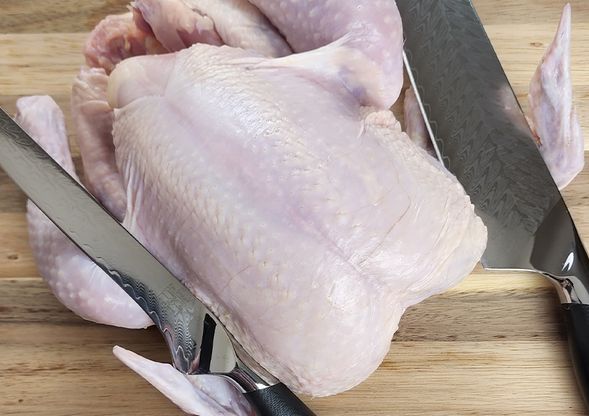 Whole raw chicken with F.N. Sharp Boning Knife and Chef's Knife