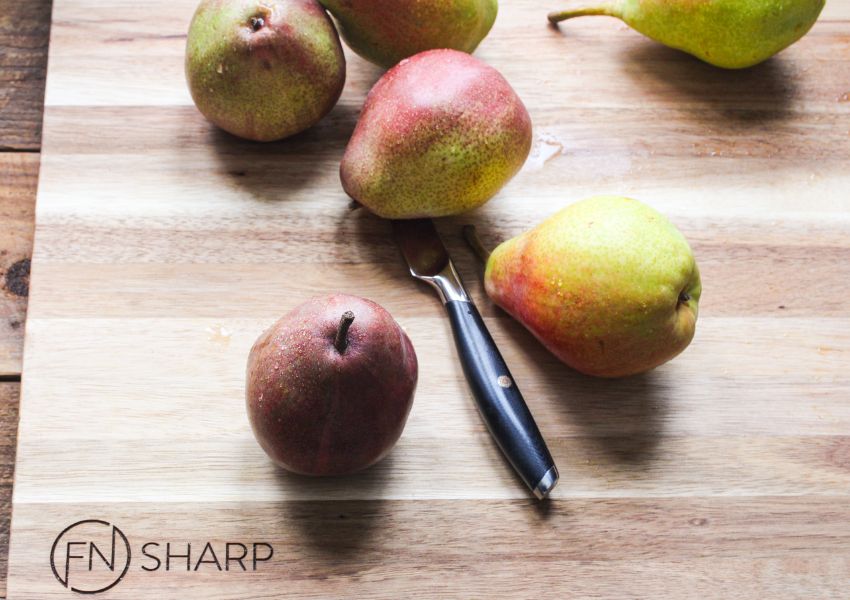 F.N. Sharp Paring Knife on Acacia Wood Cutting Board With Whole Pears