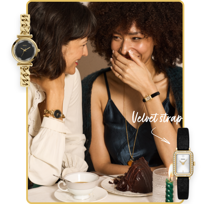 At a special dinner, two women share a laugh over cake and coffee, wearing gold and black velvet Fossil watches with sparkling detail.