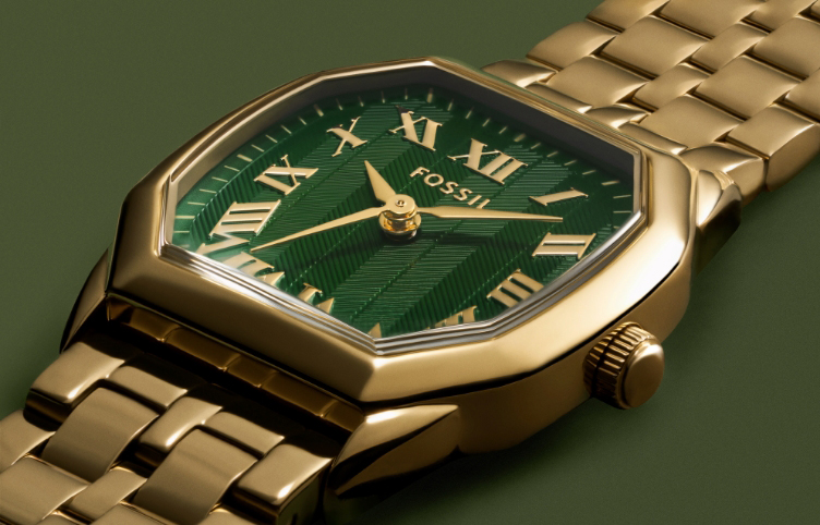 Close-up of a womens Harlow gold watch with green dial