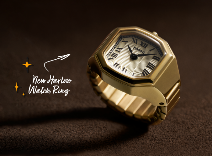Close-up of new gold Harlow watch ring with textured dial against chocolate brown background, with “New Harlow Watch Ring