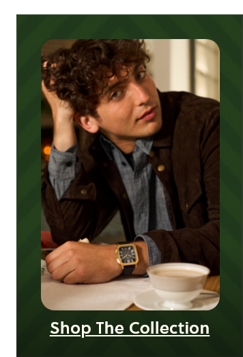Young man with curly hair sits at a table with tea, wearing a black leather strap watch with gold case and black dial. “Shop the collection” text at bottom
