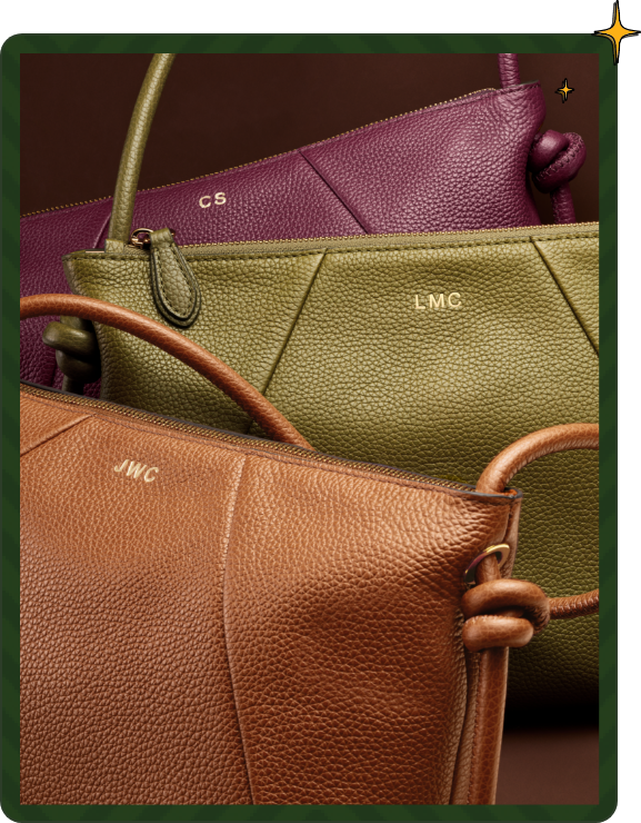Purple, green, and brown leather handbags with embossed initials displayed together
