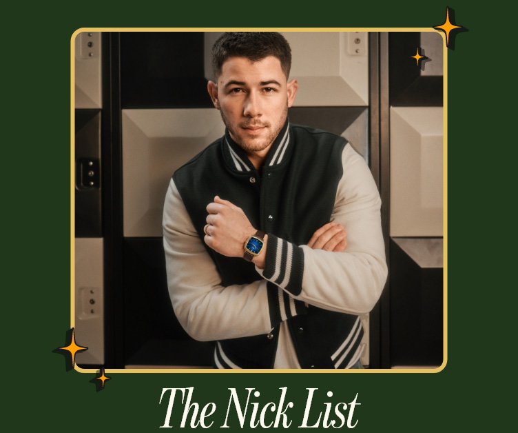Nick Jonas in a black and white vintage jacket with folded arms and a Fossil watch 