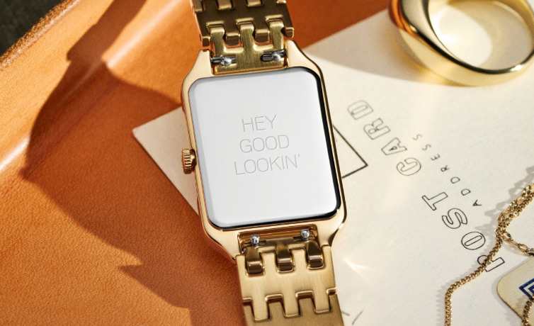 A close-up of back of watch with an engraving Hey Good Lookin