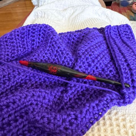 A Furls Scorpio hook (black/red) on a bright purple crochet swatch