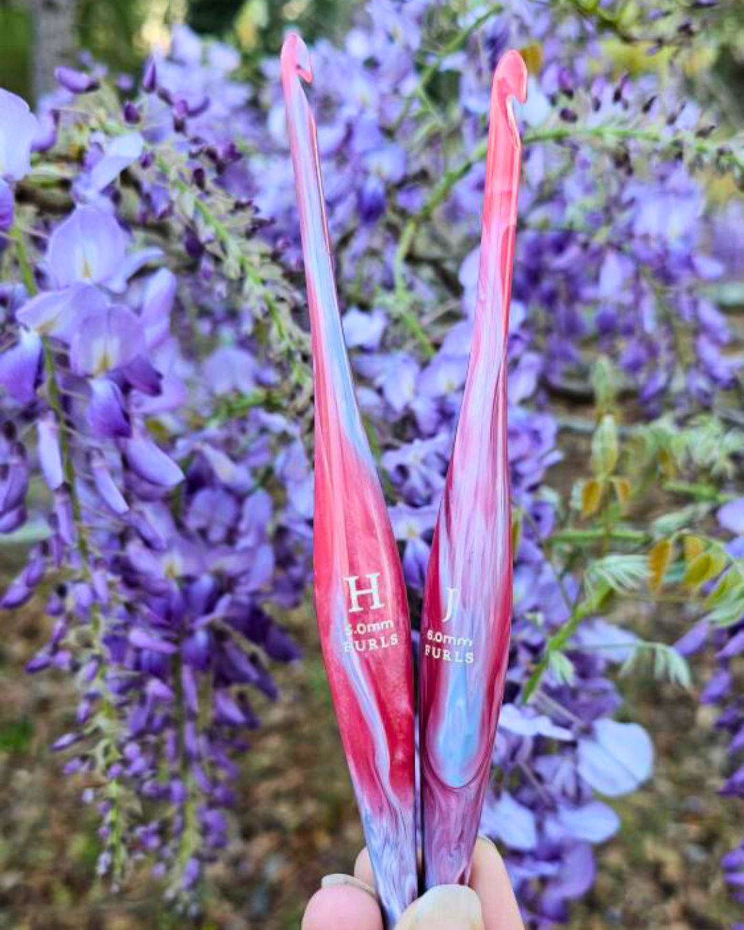 A lot of pink/lavender swirled crochet hooks together