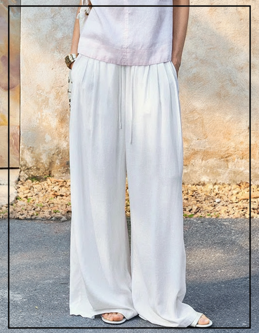 Person wearing white wide-leg pants and a light pink top, standing outdoors.