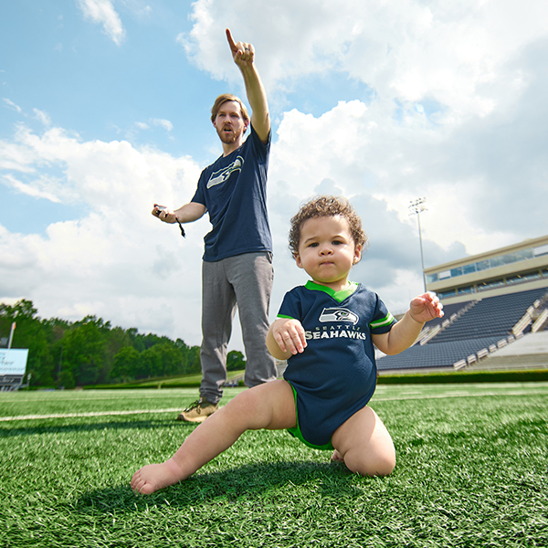 Dad and Baby on Football Field Wearing Seattle Seahawks NFL Attire