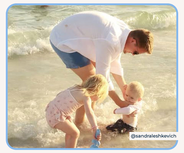 dad and kids playing in the waves wearing Gerber Rashguards