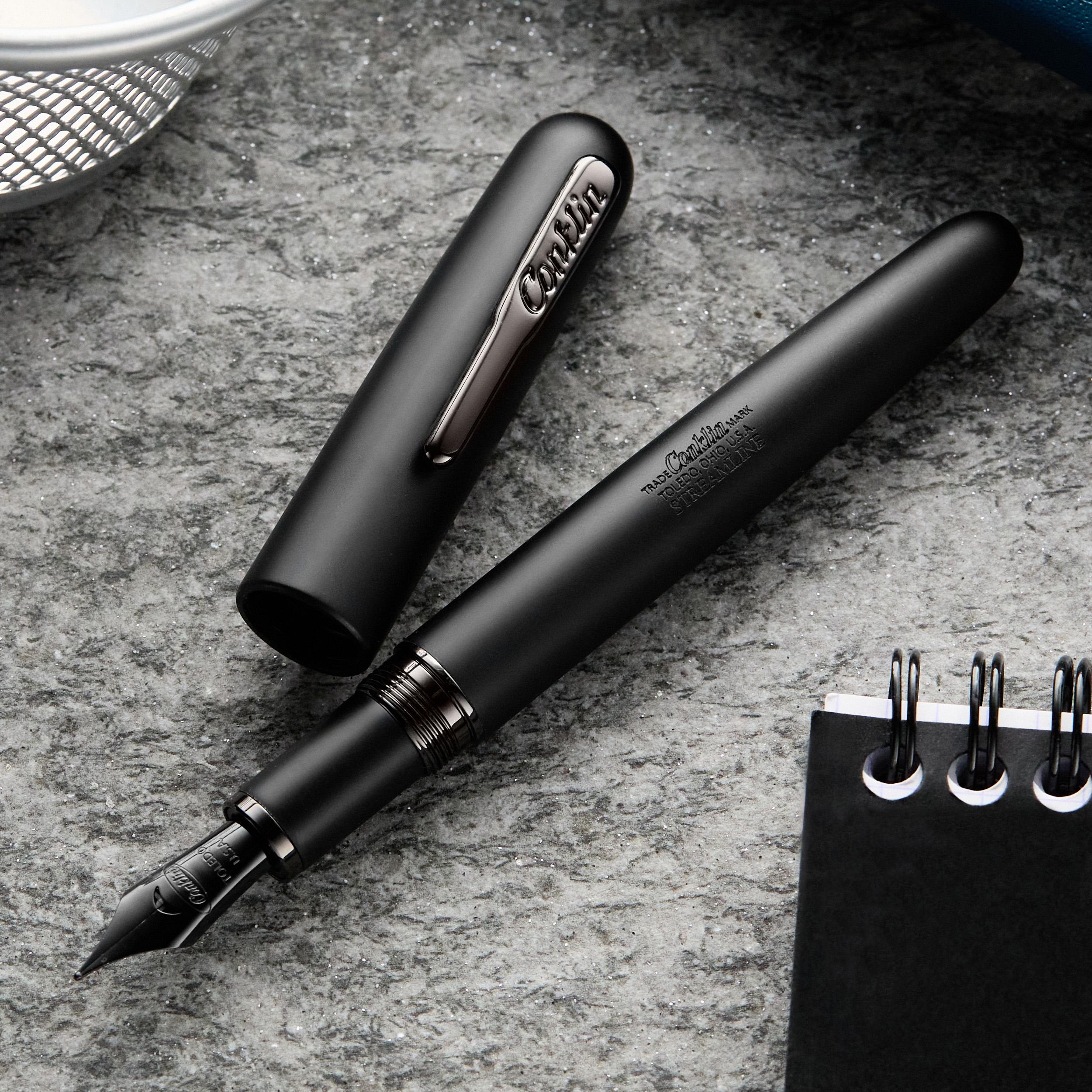 an image of a pen and notebook on a table with a cup of coffee