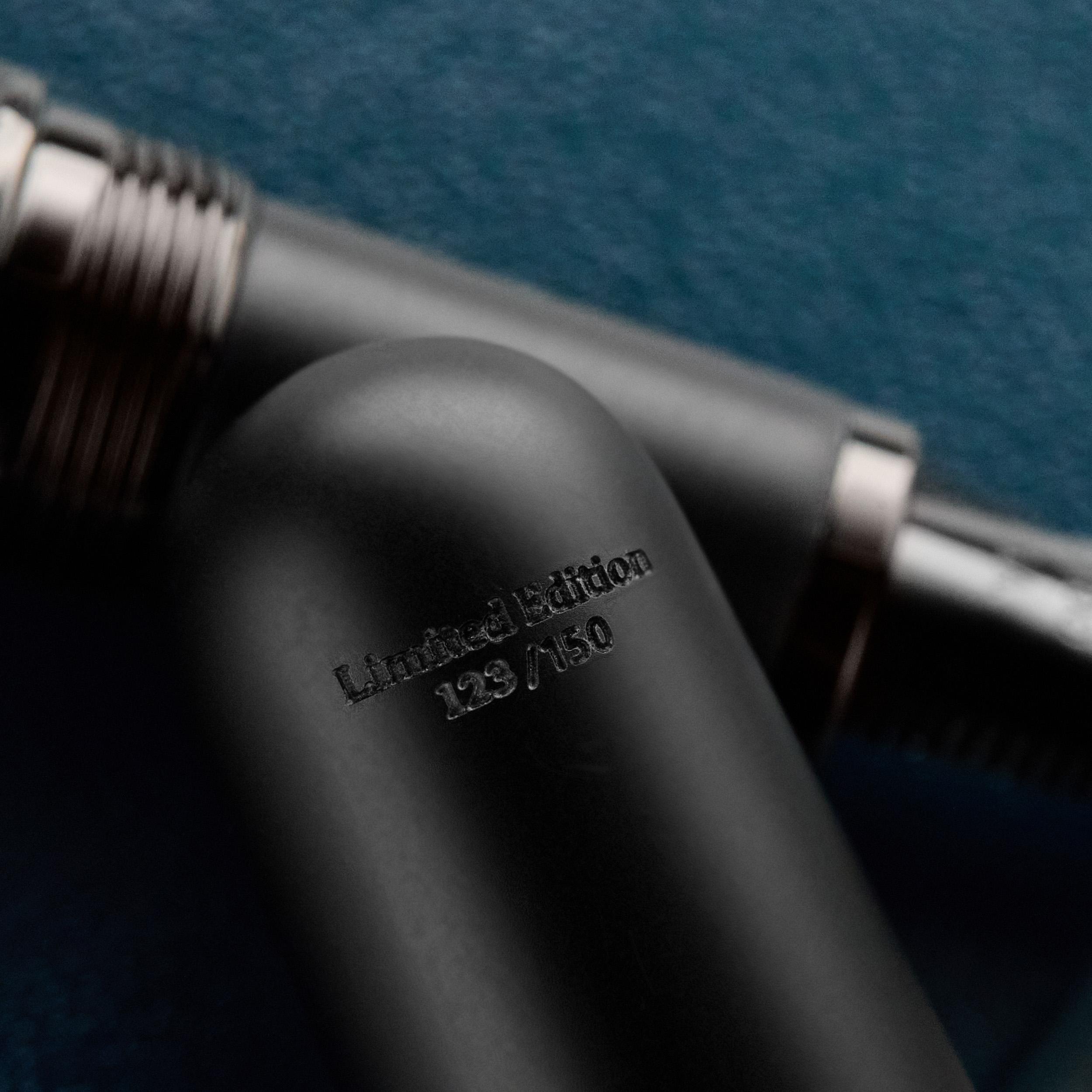 an image of a fountain pen and a pen cap on a blue surface
