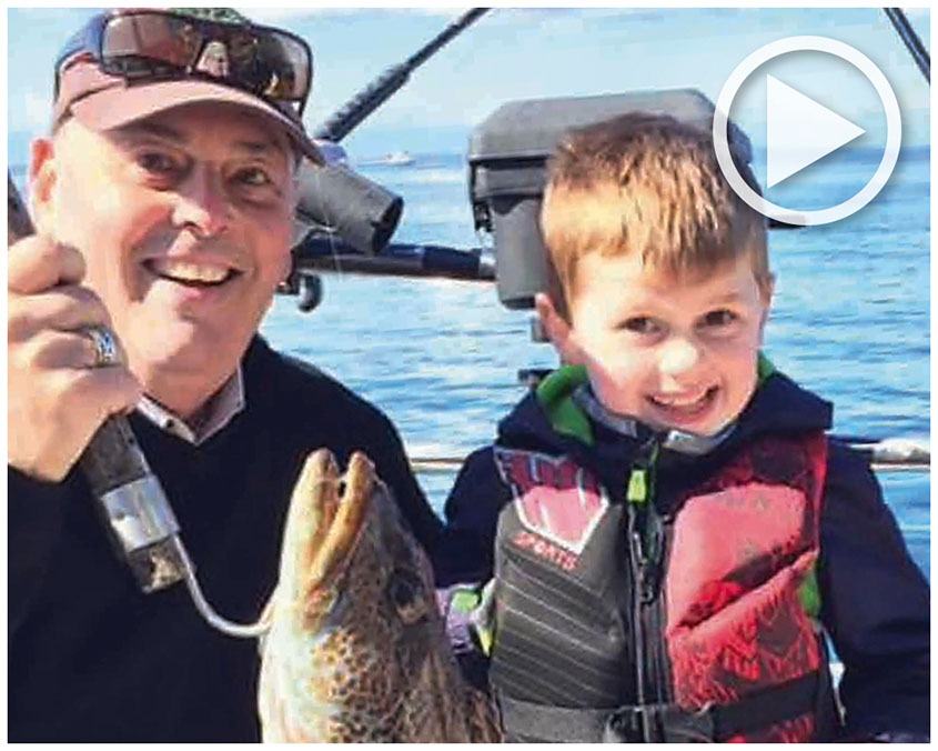 Grandfather and grandson holding up a fish they caught aboard a Grady-White boat