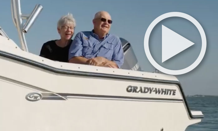 Man and woman sitting in the cockpit of a Grady-White boat