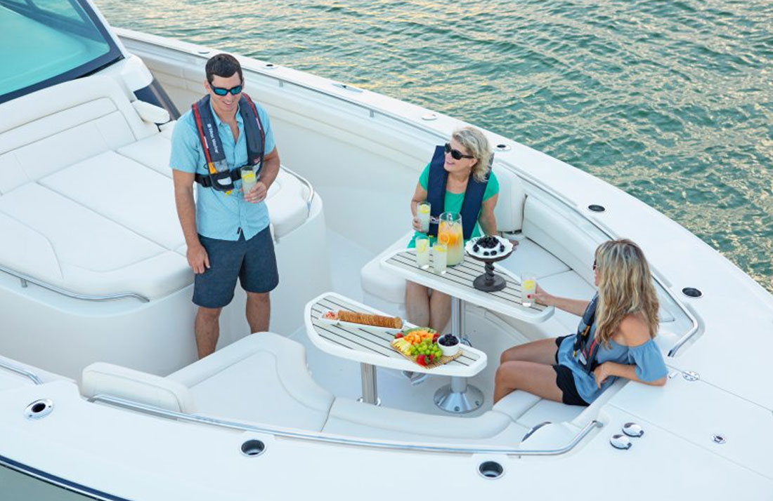 Three people in the bow of a Grady-White boat