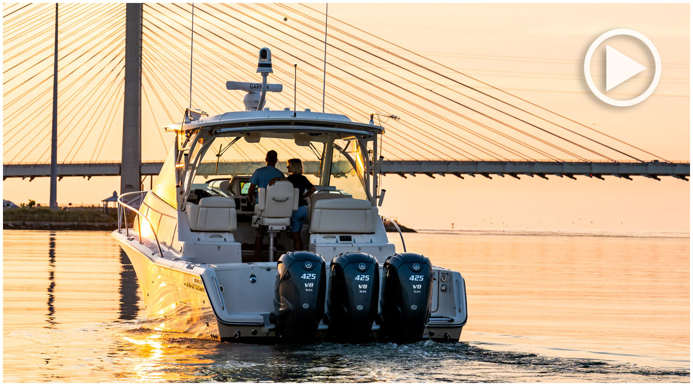 Grady-White Express 370 approaching a bridge at sunset with two people aboard