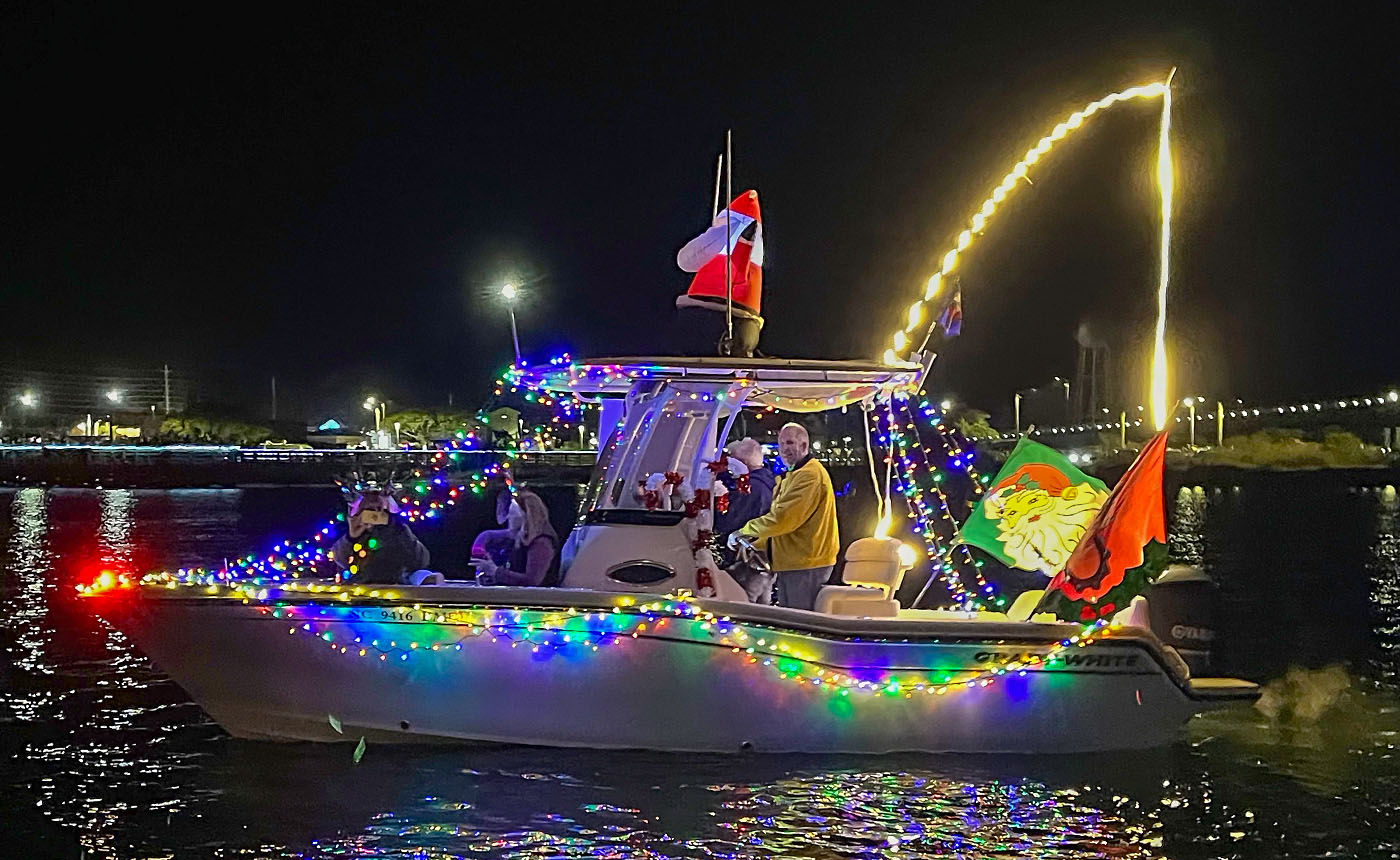 Grady owner's boat decorated with Christmas lights and an inflatable Santa with multiple people at the helm and in the bow