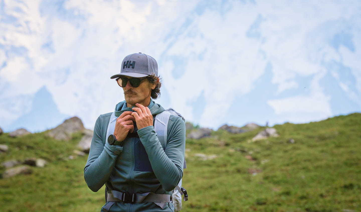 A hiker in Helly Hansen Gear in front of mountains
