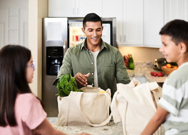 A family unpacking groceries in a kitchen.