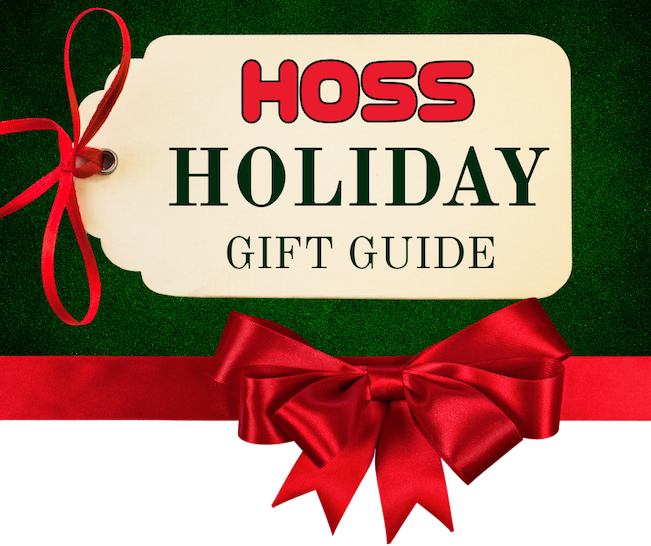 A Christmas gift tag with the Hoss logo on it, along with the words Holiday Gift Guide underneath. It’s laying on a green background and has a red gift ribbon lining the bottom of it. 