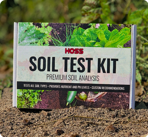HOSS Soil Test Kit box sitting on garden soil, labeled “Premium Soil Analysis” with images of leafy vegetables on the packaging.