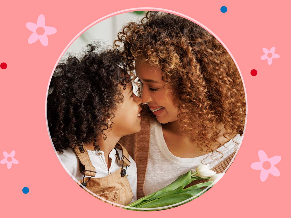 A mother and her young child rub noses in a warm embrace.