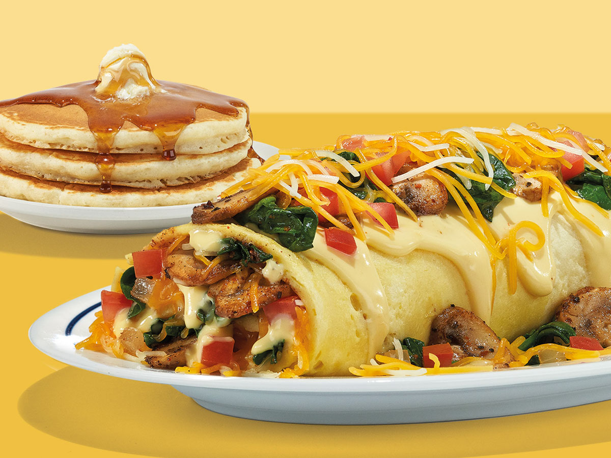 Photo of an IHOP Omelette with a side of pancakes topped with syrup and butter