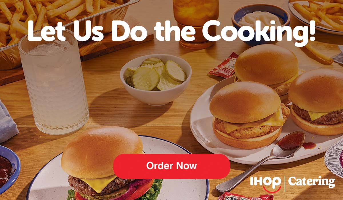  Image of IHOP SteakBurgers and chicken sandwiches, with a side of pickles in a small bowl. Some drinks and a tin of french fries are also on the table