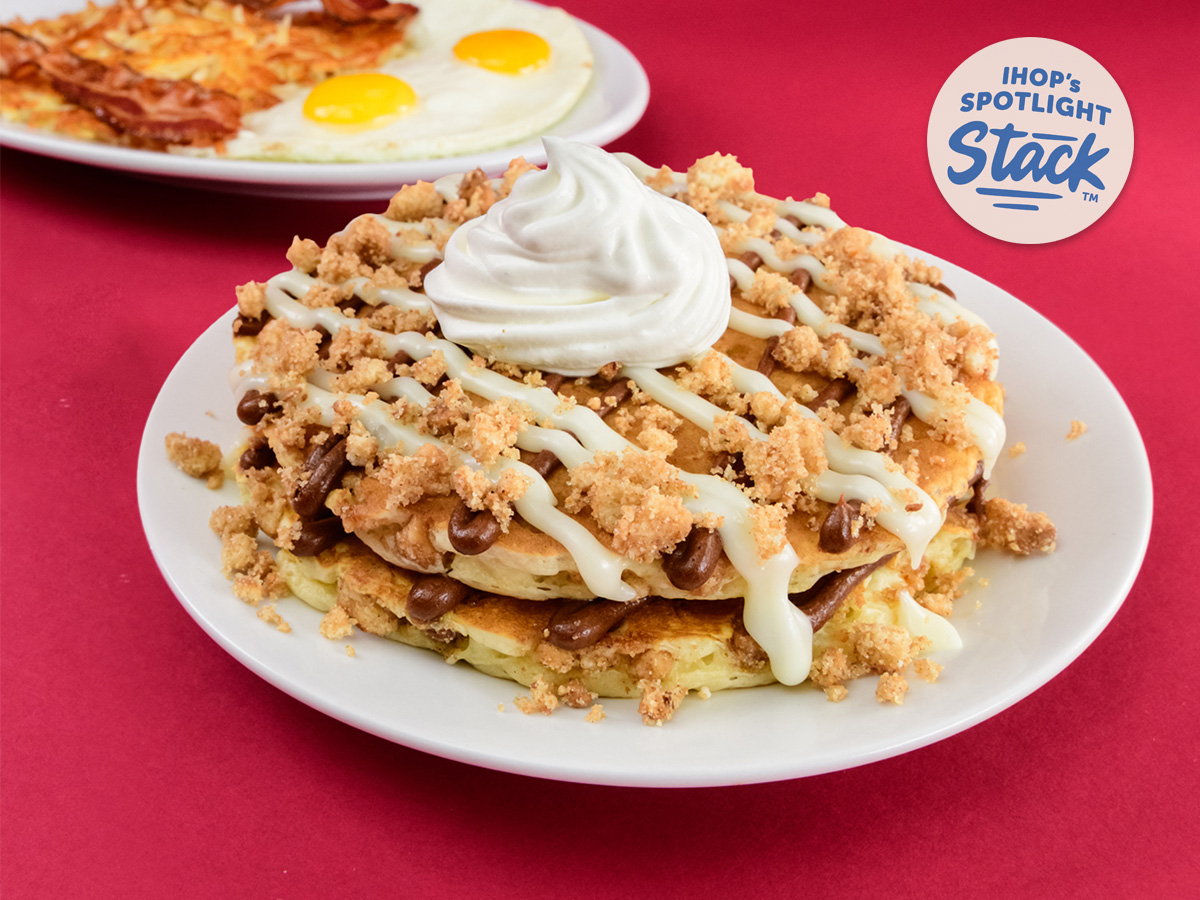 The Coffee Cake Pancakes Combo, featuring a plate of Coffee Cake pancakes and a second plate of eggs, bacon, and hashbrowns behind it.