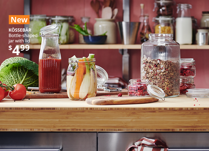 A kitchen where a table and shelves are adorned with KÖSSEBÄR items, like jars, baskets, tea towels, aprons and more.