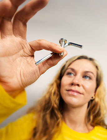 Person holding a screw and an allen key