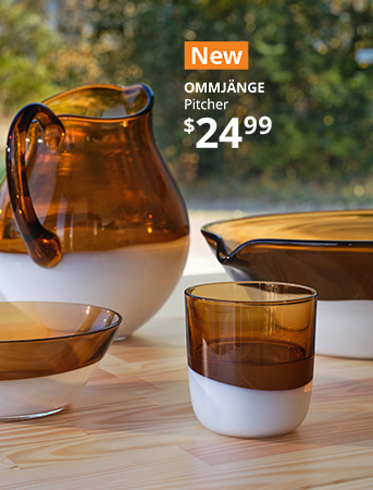 A handblown glass pitcher, serving bowl, drinking glass and bowl displayed on a table.