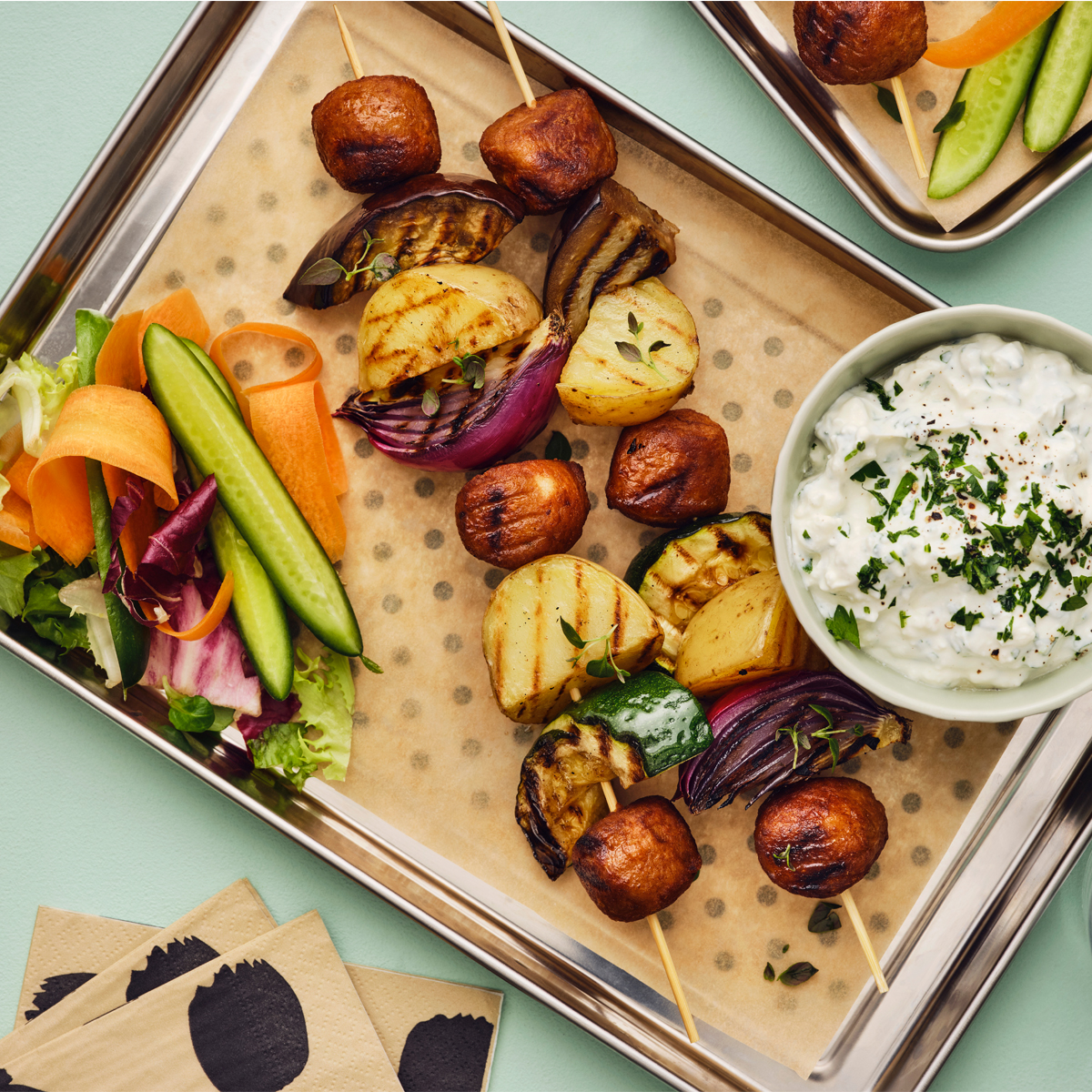 Skewers with meatballs and veggies on tray. 
