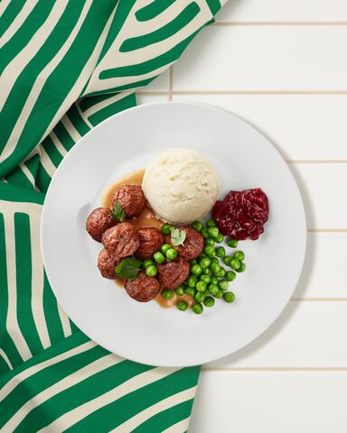 IKEA Meatballs on a plate with mashed potatoes, peas, and lingonberry sauce