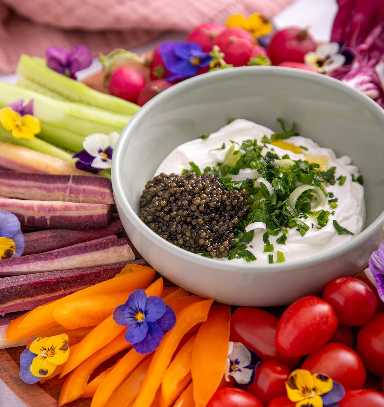 an image of a plate of vegetables and dip with a bowl of dip