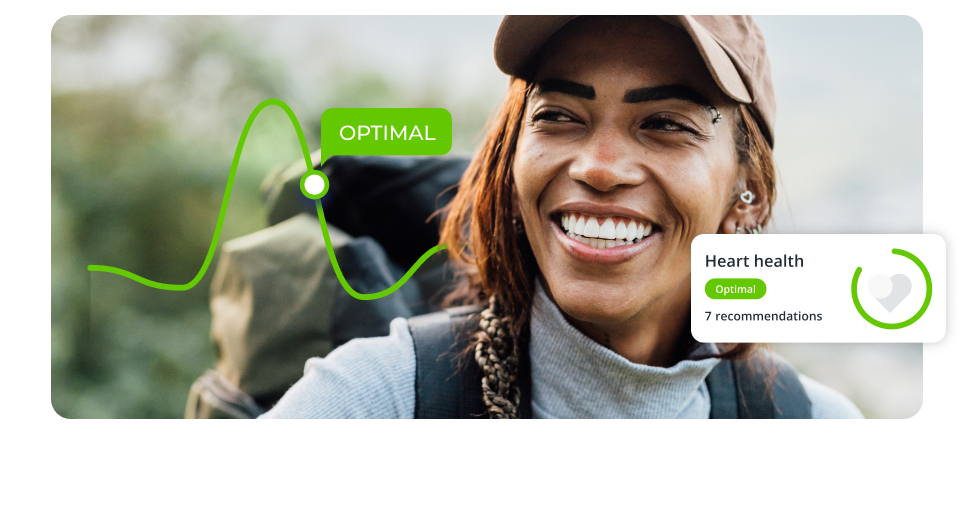 Woman hiking the mountains with a screen overlay showing Heart Health Optimal 7 recommendations. There is a green line of a graph in the image with a data point that says Optimal.