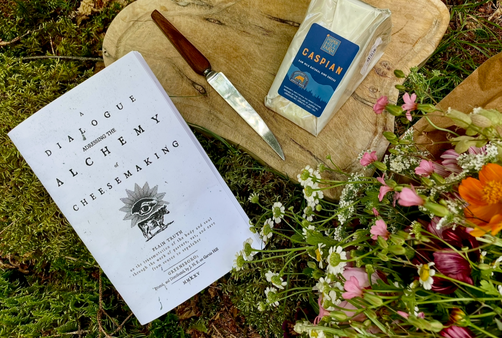 a wedge of caspian with wildlfowers and a pamphlet on alchemy