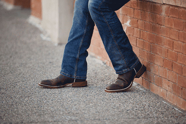 A close-up of a man wearing Justin western boots.