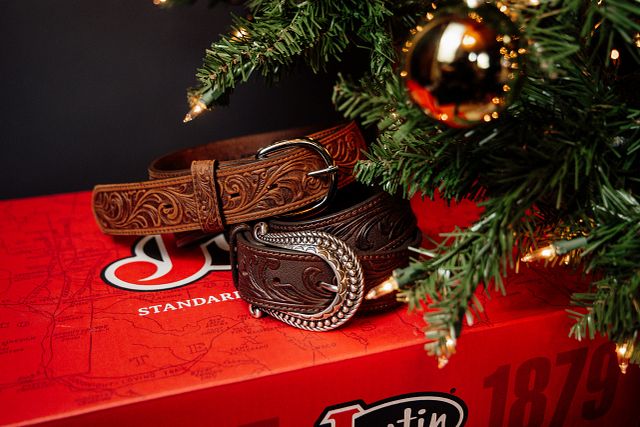 A Justin belt in brown under a Christmas tree.