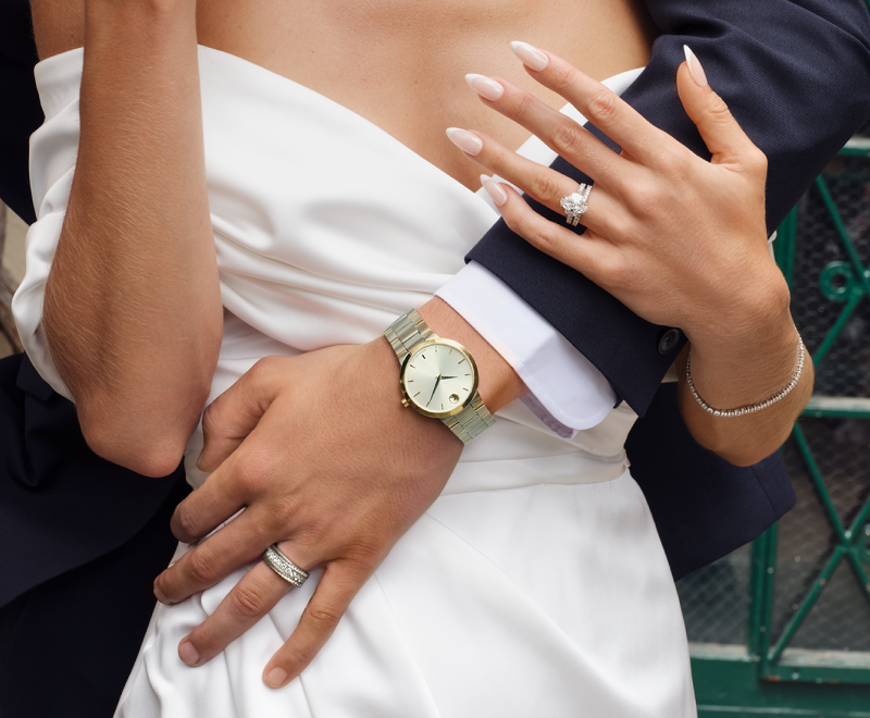 Groom Holding Bride, Showcasing Watches Bracelet and Rings.