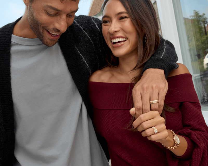 Couple showcasing rings and watch.