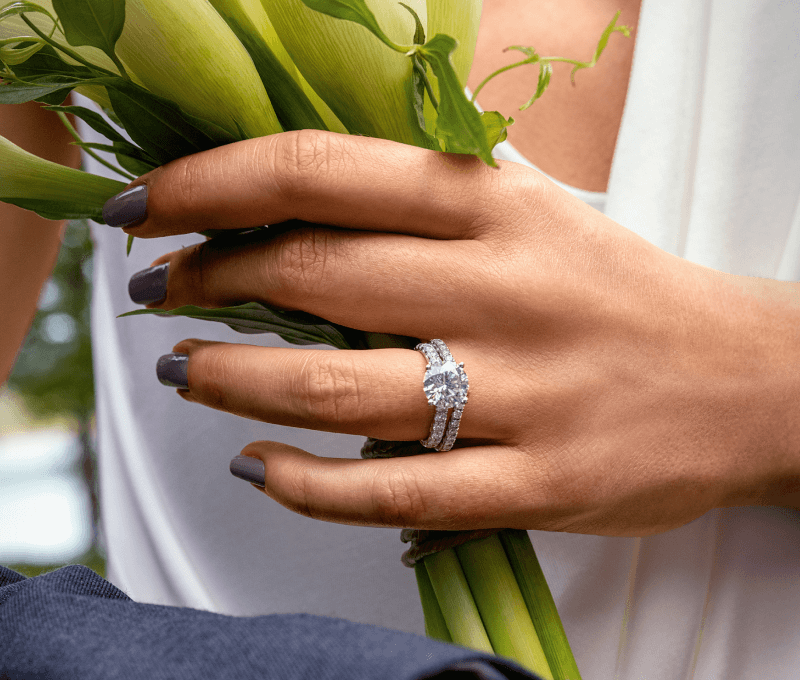 Closeup of a woman's hand displaying engagement and wedding rings